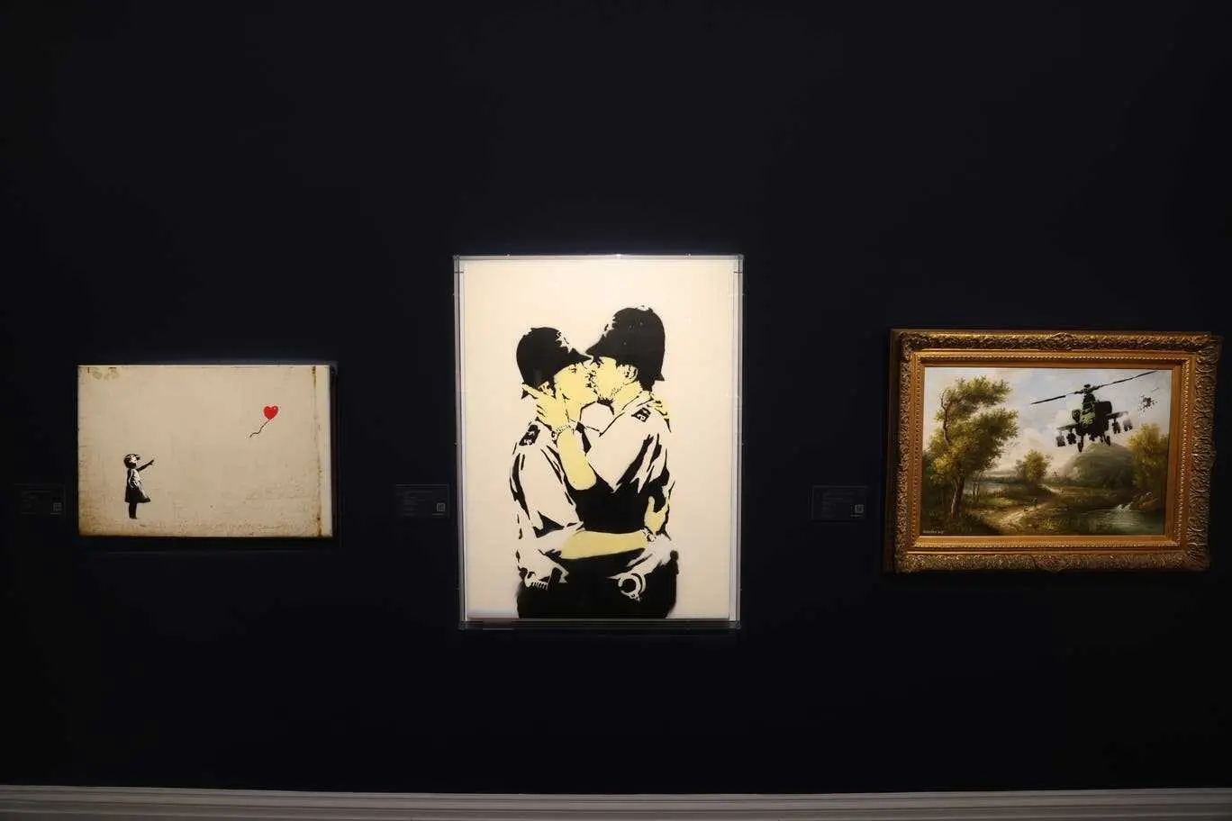 Girl with Balloon, Kissing Coppers and Vandalised Oil (Choppers) by Banksy from singer Robbie Williams’ personal collection are going under the hammer at Sotheby’s, London on 2 March 2022.