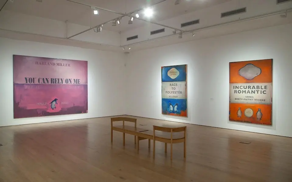 Installation view of Harland Miller's Rags to Polyester – My Story, reportedly owned by Rishi Sunak and Akshata Murthy next to Incredible Romantic, once in George Michael’s art collection.